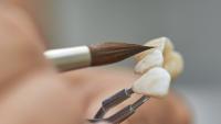 Closeup of dental technician putting ceramic to dental implants in their laboratory